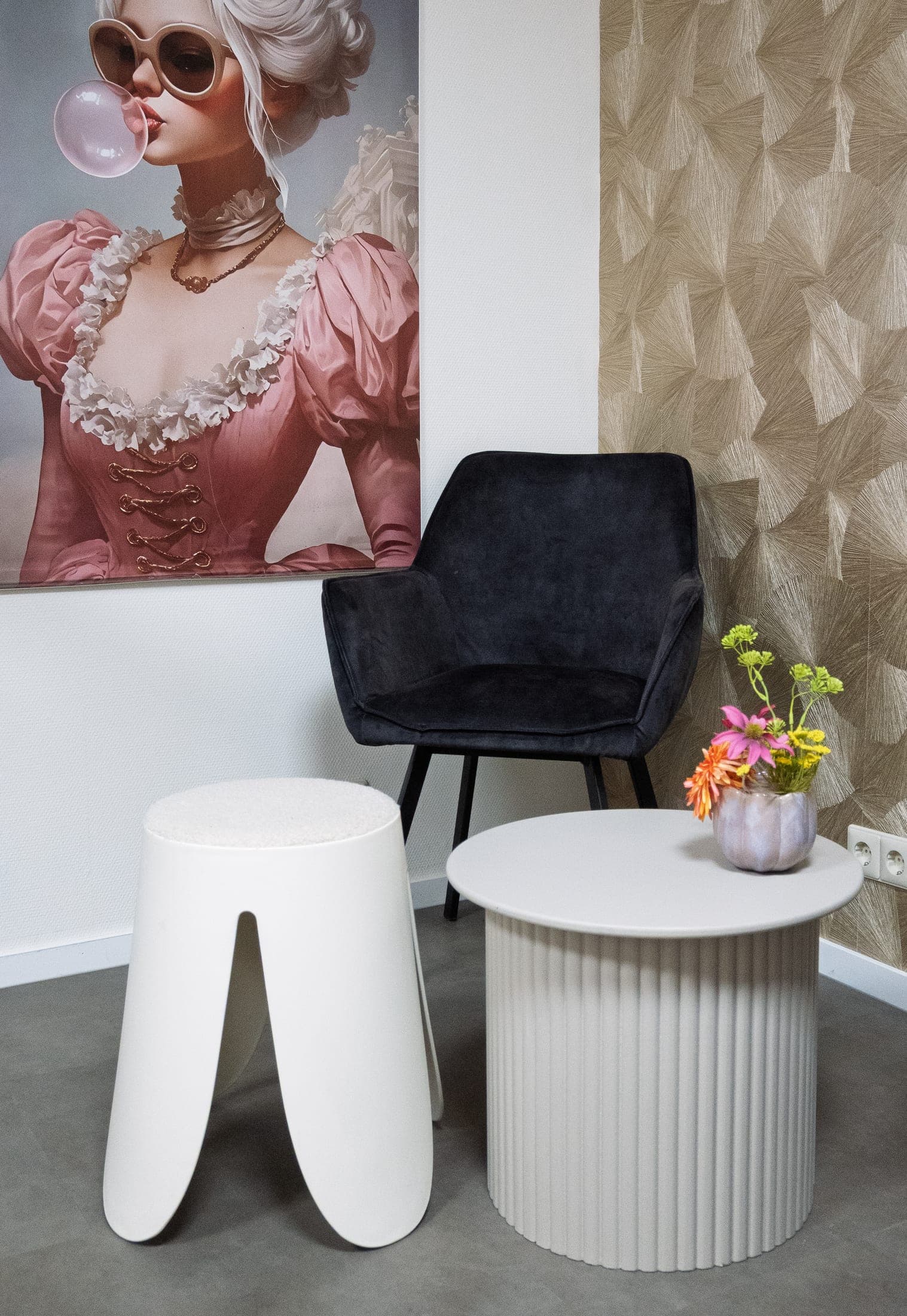 Een warme wachthoek met een fauteuil, een bijzettafel en een schilderij aan de muur.