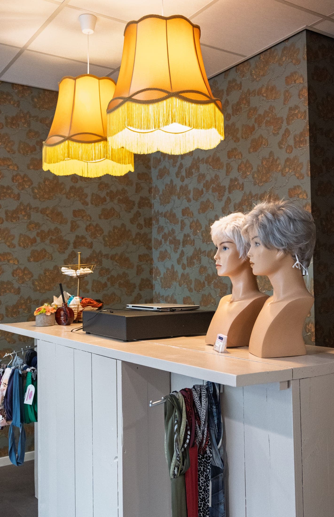Haarwerken op pruikenhoofden aan de balie van Hair Professionals.