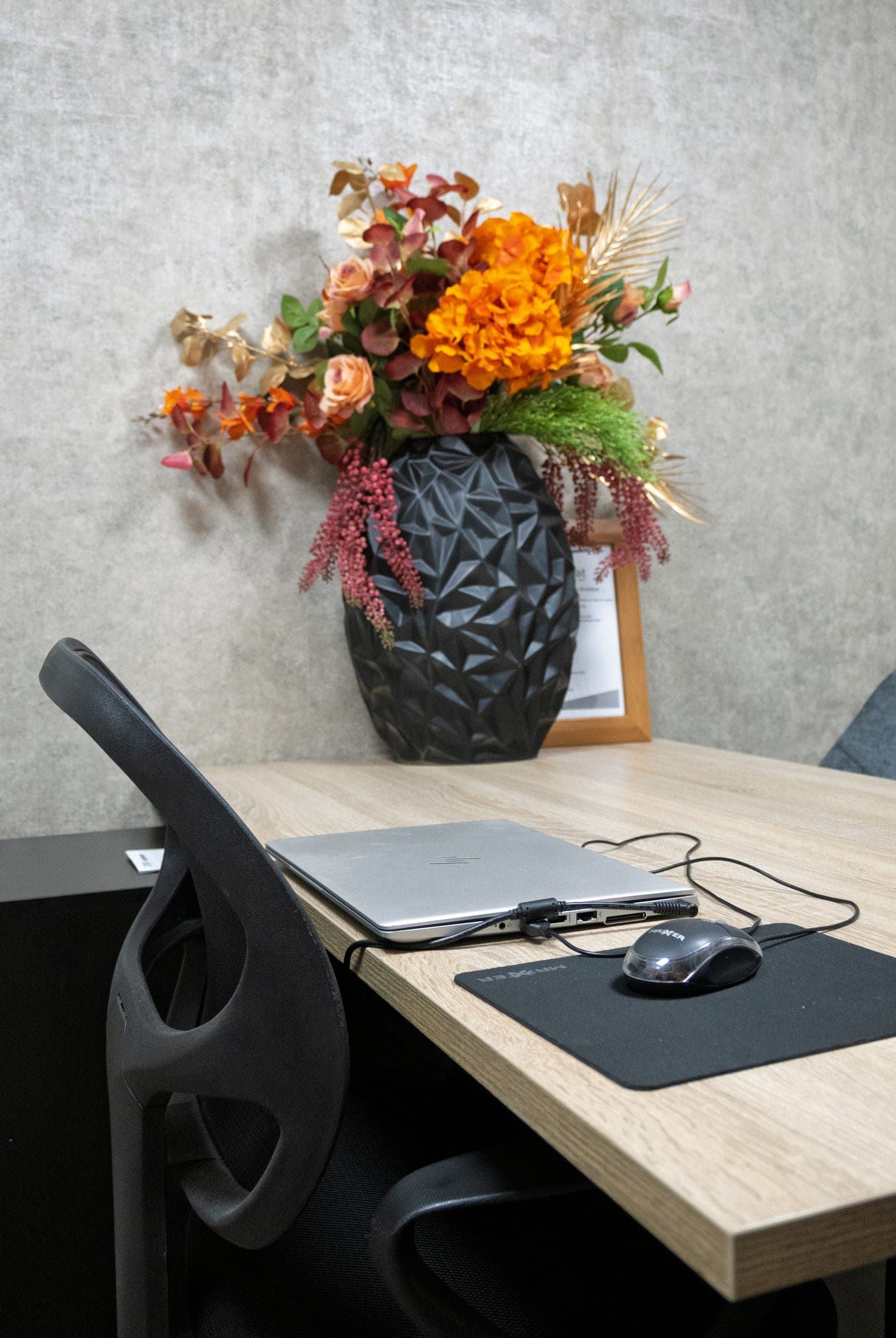 De plek waar het intakegesprek plaatsvindt: een bureau met verse bloemen in de zaak.